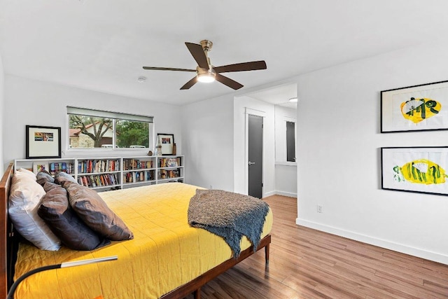 bedroom featuring a ceiling fan, baseboards, and wood finished floors