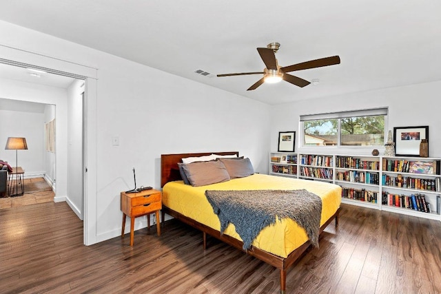 bedroom featuring visible vents, ceiling fan, baseboards, and wood finished floors