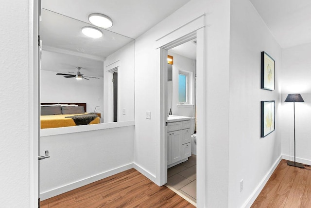 hall with light wood-style flooring and baseboards