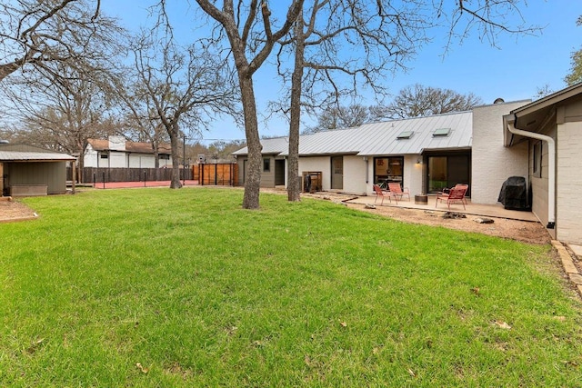 view of yard with an outbuilding, a patio, a storage unit, and fence