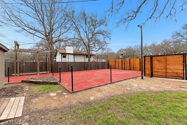 view of basketball court with fence and basketball court