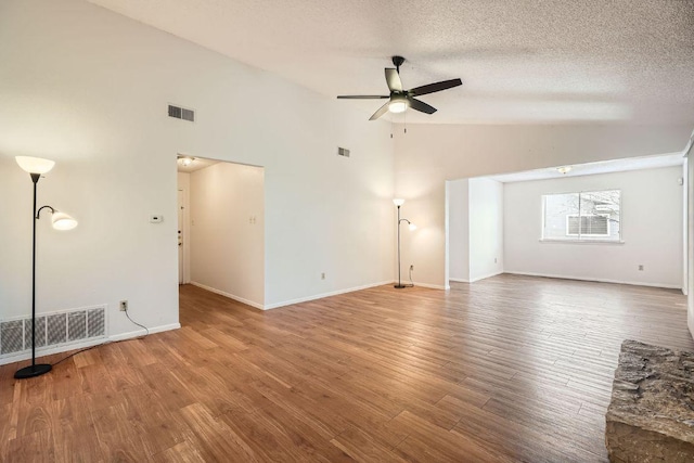 unfurnished living room with lofted ceiling, wood finished floors, and visible vents