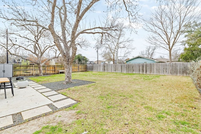 view of yard featuring a patio area, a fenced backyard, and an outdoor structure