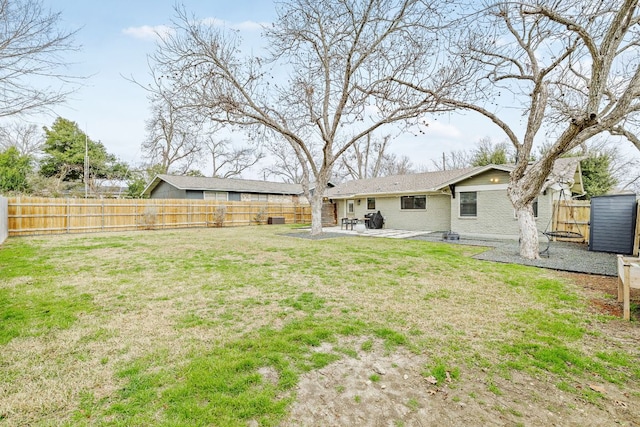 rear view of property featuring a yard, a patio area, and a fenced backyard