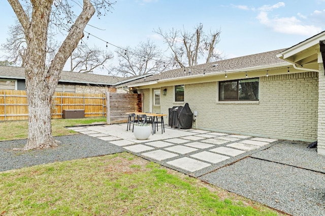 back of property with a patio area, brick siding, fence, and central air condition unit