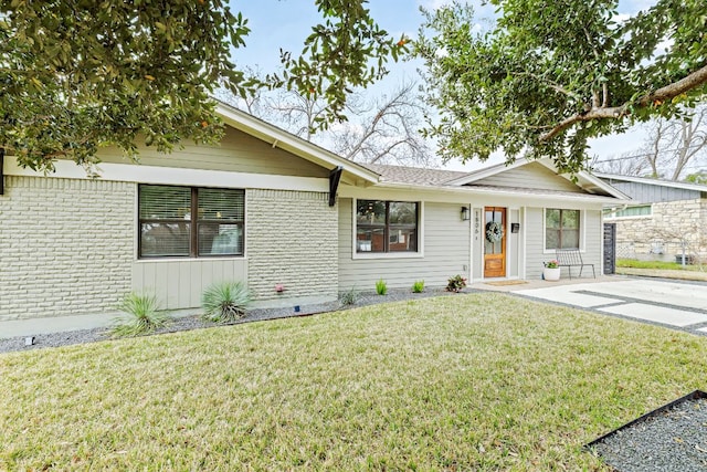 ranch-style home with brick siding and a front lawn