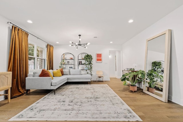 living room featuring a chandelier, recessed lighting, visible vents, baseboards, and light wood-type flooring