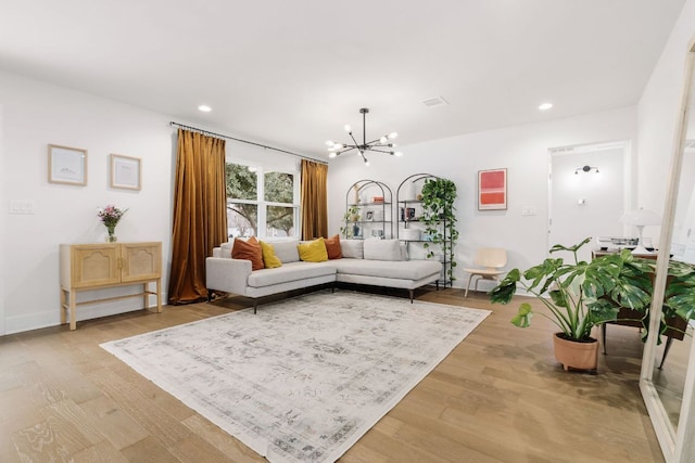 living room featuring light wood-style flooring, baseboards, a notable chandelier, and recessed lighting