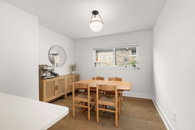 dining area with light wood-style flooring and baseboards