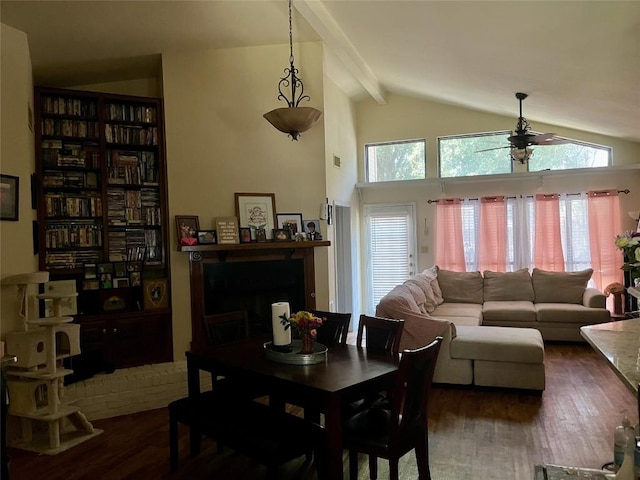 dining space featuring vaulted ceiling with beams, dark wood-style floors, ceiling fan, and a fireplace