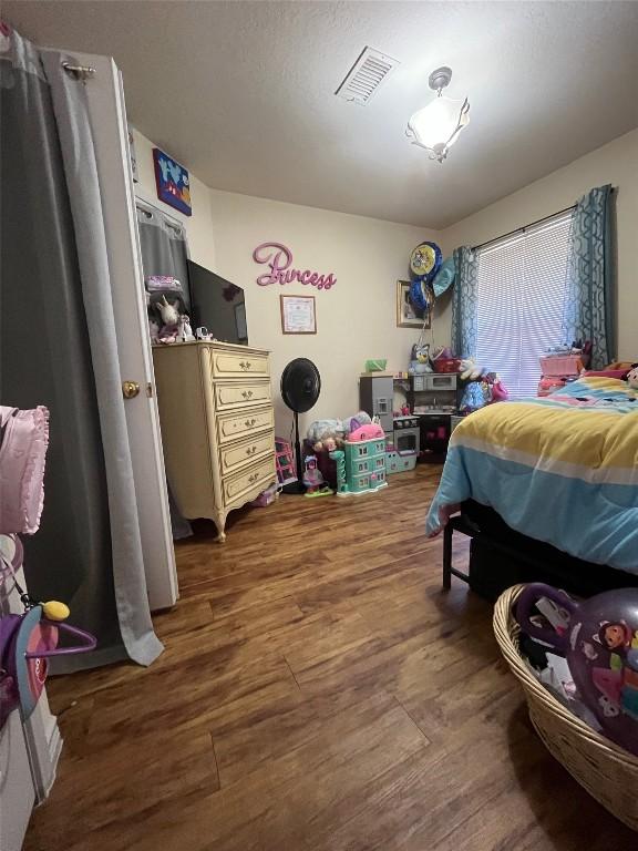 bedroom with visible vents and wood finished floors