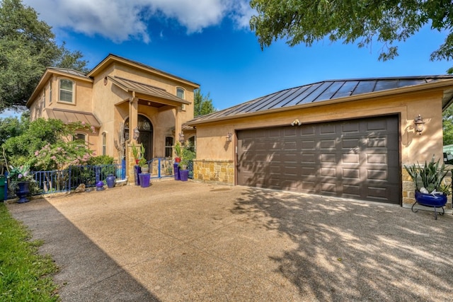 view of front of home featuring a standing seam roof, stone siding, metal roof, and stucco siding