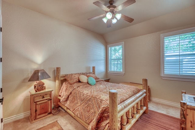 bedroom with a ceiling fan, light colored carpet, and baseboards