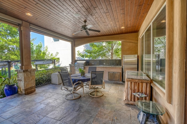 view of patio / terrace featuring outdoor dining space, ceiling fan, an outdoor kitchen, and area for grilling