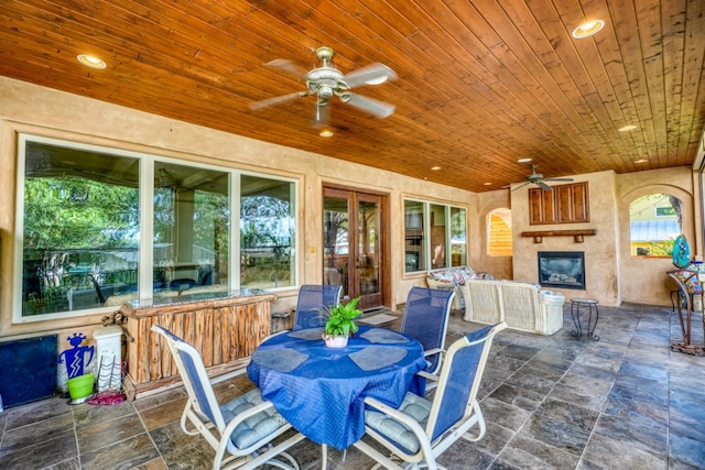 exterior space with a ceiling fan, outdoor dining area, and a fireplace