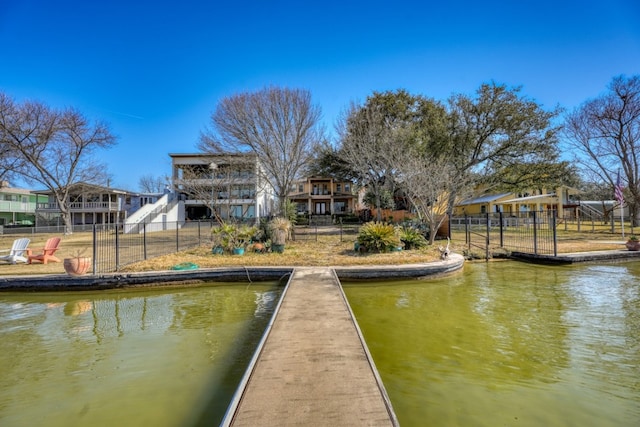 view of dock featuring a water view, fence, and stairway