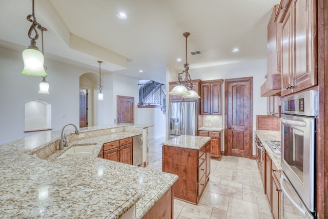 kitchen featuring a large island, tasteful backsplash, visible vents, appliances with stainless steel finishes, and a sink