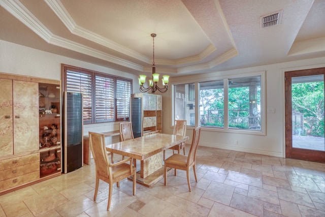 dining room featuring stone tile floors, visible vents, an inviting chandelier, a raised ceiling, and crown molding