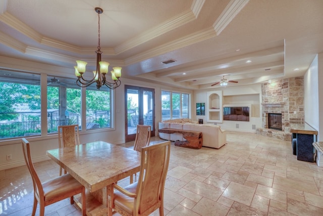 dining space featuring a healthy amount of sunlight, a fireplace, and a tray ceiling