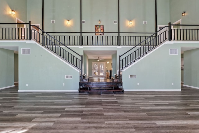 unfurnished living room with stairs, wood finished floors, and visible vents