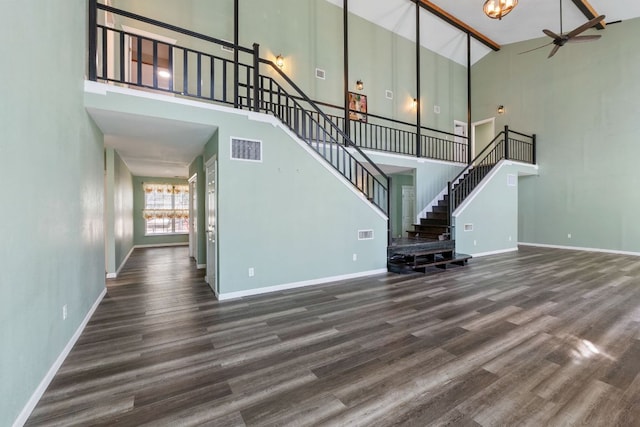 unfurnished living room with baseboards, stairs, visible vents, and wood finished floors