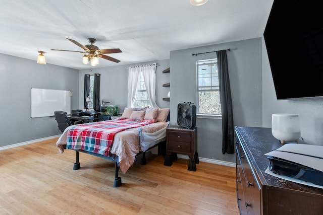 bedroom with light wood-style floors, ceiling fan, and baseboards