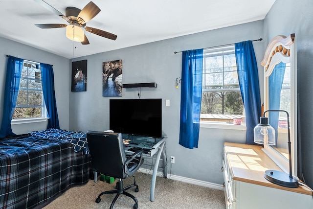 carpeted bedroom with ceiling fan and baseboards