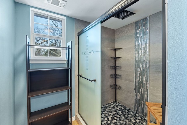 bathroom with a stall shower and visible vents