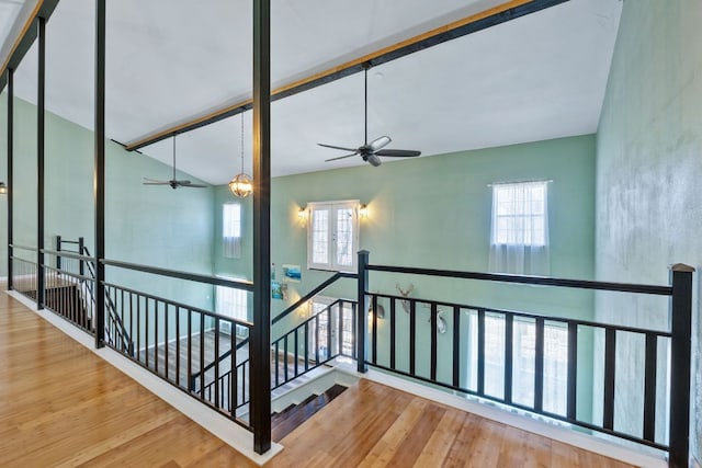 hall featuring high vaulted ceiling, an upstairs landing, and wood finished floors