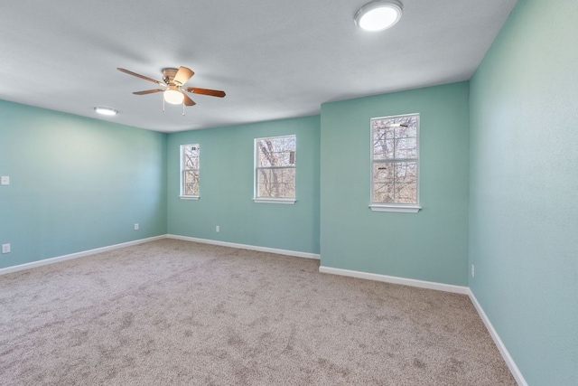 empty room featuring carpet floors, ceiling fan, and baseboards