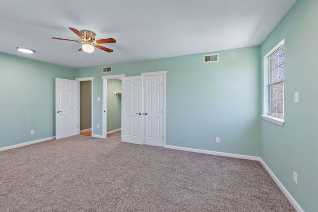 unfurnished bedroom with carpet flooring, visible vents, and baseboards