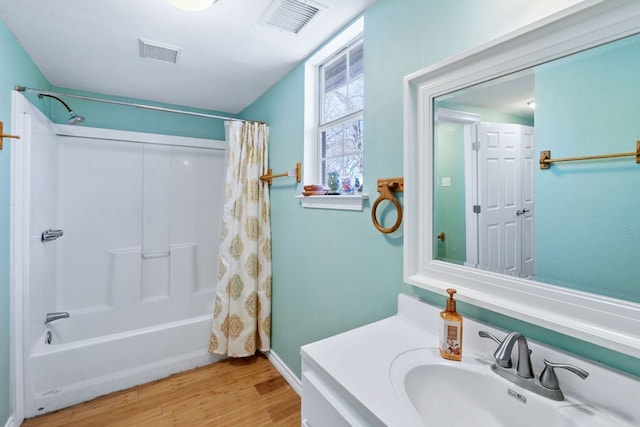 bathroom featuring shower / bath combination with curtain, vanity, wood finished floors, and visible vents