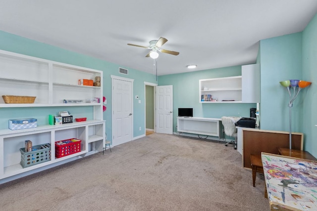 carpeted office space with baseboards, visible vents, and a ceiling fan