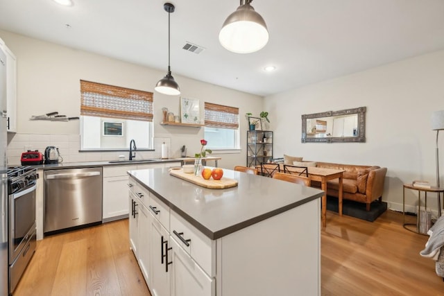 kitchen featuring light wood-style floors, visible vents, stainless steel appliances, and a sink