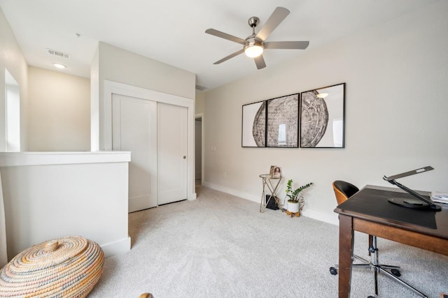 office space featuring carpet floors, visible vents, baseboards, and a ceiling fan