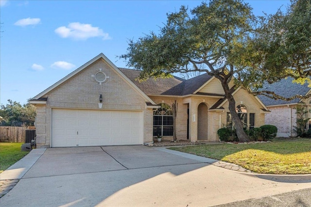 view of front of house with driveway, a garage, fence, a front lawn, and brick siding