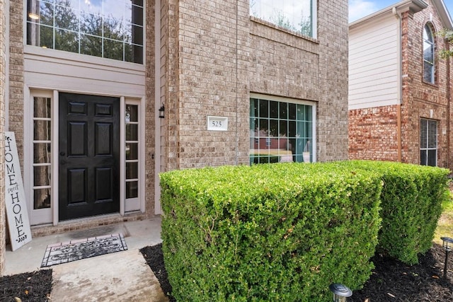 entrance to property featuring brick siding