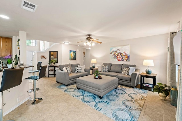 living area with light tile patterned floors, ceiling fan, and visible vents