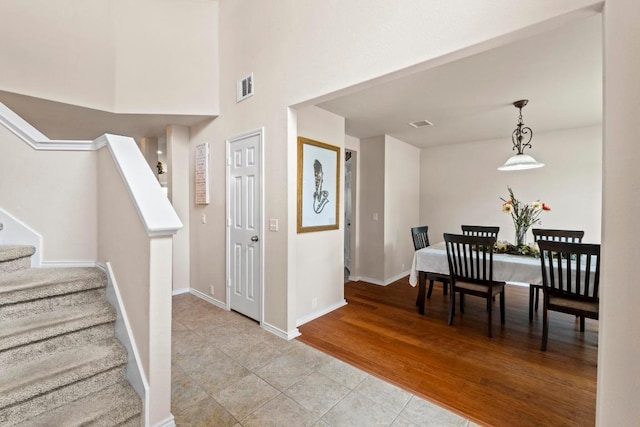 entryway with visible vents, stairway, baseboards, and light wood finished floors