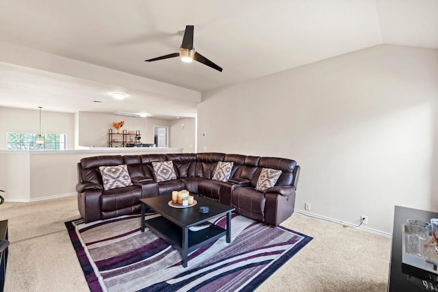 carpeted living area with a ceiling fan, vaulted ceiling, and baseboards