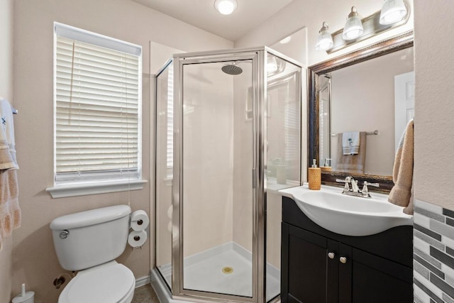 bathroom featuring a shower stall, toilet, and vanity