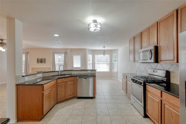 525 Golden Creek Dr, Round Rock, TX 78665 - kitchen with appliances with stainless steel finishes, backsplash, light tile patterned floors, dark stone counters, and recessed lighting