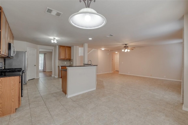 525 Golden Creek Dr, Round Rock, TX 78665 - kitchen featuring appliances with stainless steel finishes, dark countertops, ceiling fan, baseboards, and open floor plan