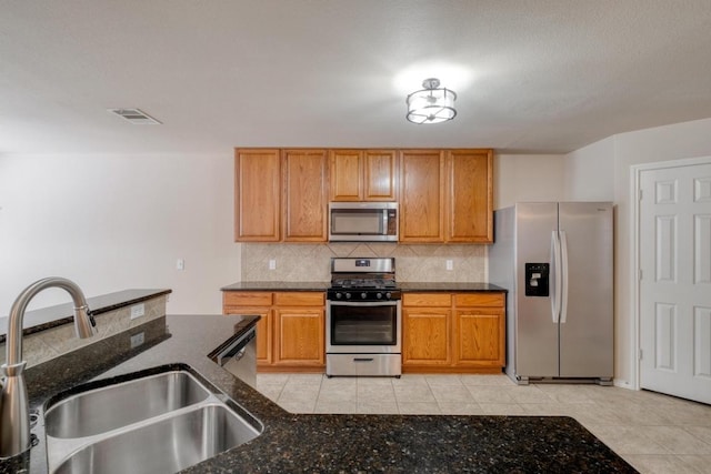 525 Golden Creek Dr, Round Rock, TX 78665 - kitchen with appliances with stainless steel finishes, a sink, tasteful backsplash, dark stone counters, and light tile patterned flooring