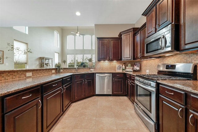 kitchen featuring stainless steel appliances, backsplash, and light tile patterned flooring