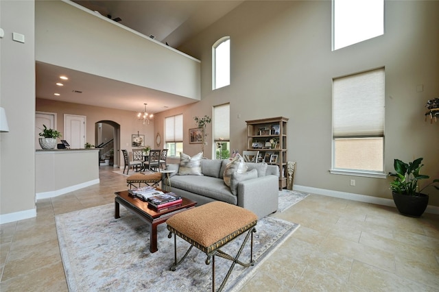 living area with arched walkways, light tile patterned floors, recessed lighting, an inviting chandelier, and baseboards