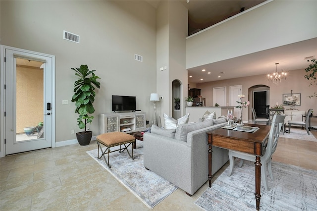 living room featuring arched walkways, baseboards, visible vents, and an inviting chandelier