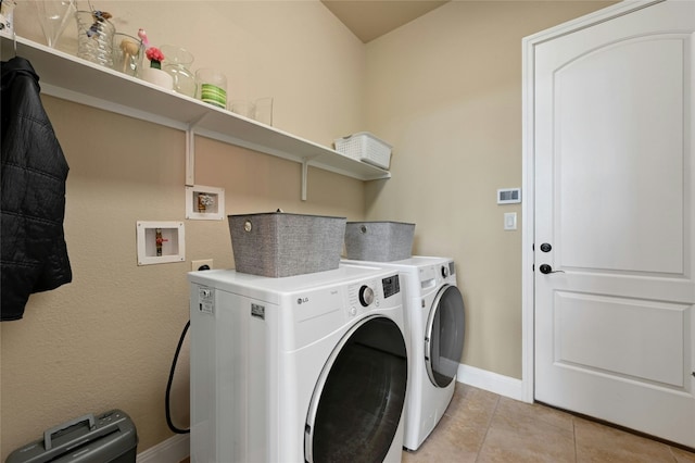 laundry room with light tile patterned floors, laundry area, washing machine and dryer, and baseboards