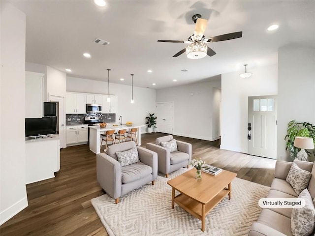 living room with recessed lighting, visible vents, and dark wood finished floors