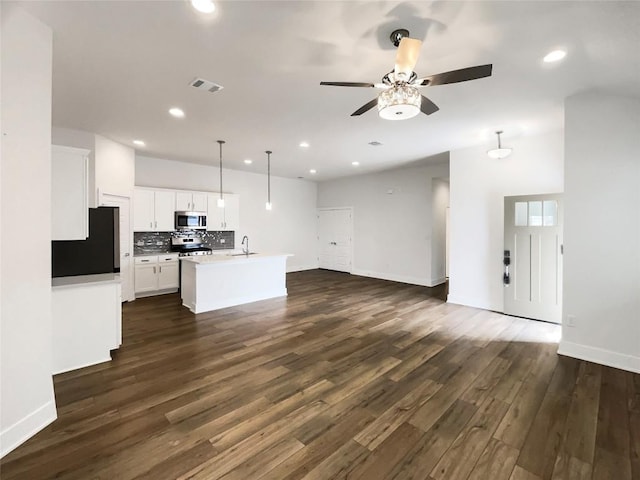 kitchen featuring tasteful backsplash, visible vents, appliances with stainless steel finishes, open floor plan, and a sink